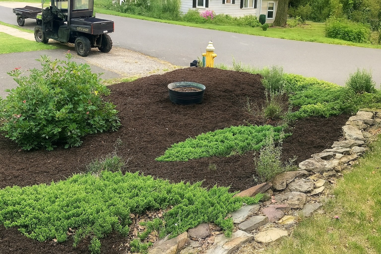 Professional seasonal landscaping with fresh mulch, plants, and stone borders
